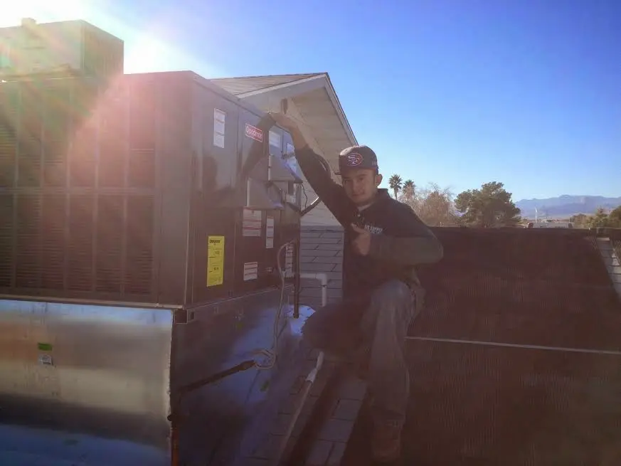 HVAC technician performing Heat Pump Repair on a rooftop unit in Old Tappan